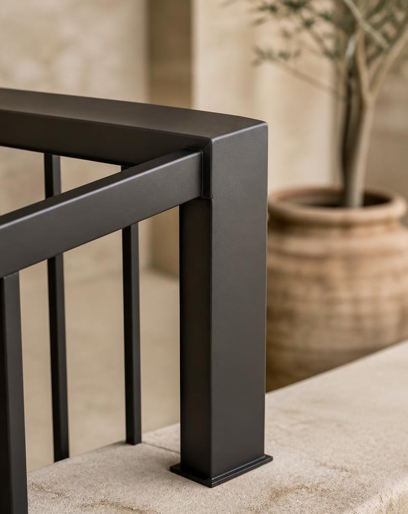 Detail van een zwarte stalen balustrade op een stenen terras